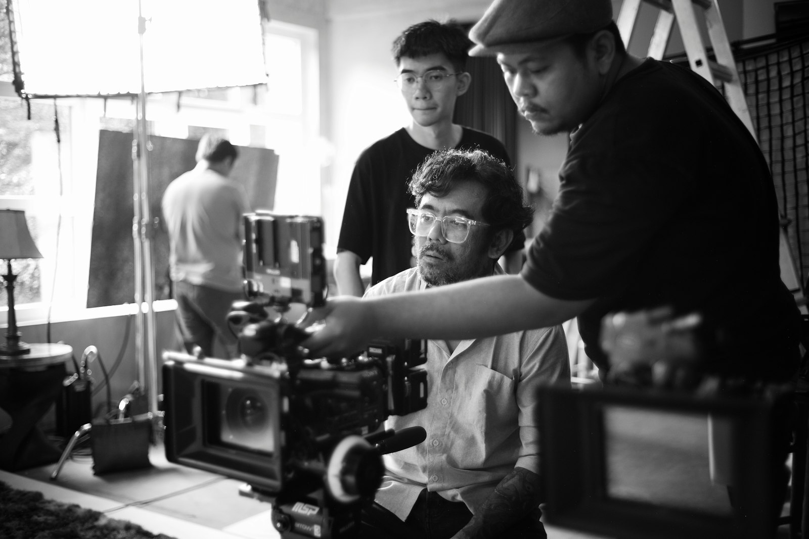 Équipe de tournage réunie autour d'une caméra dans un intérieur